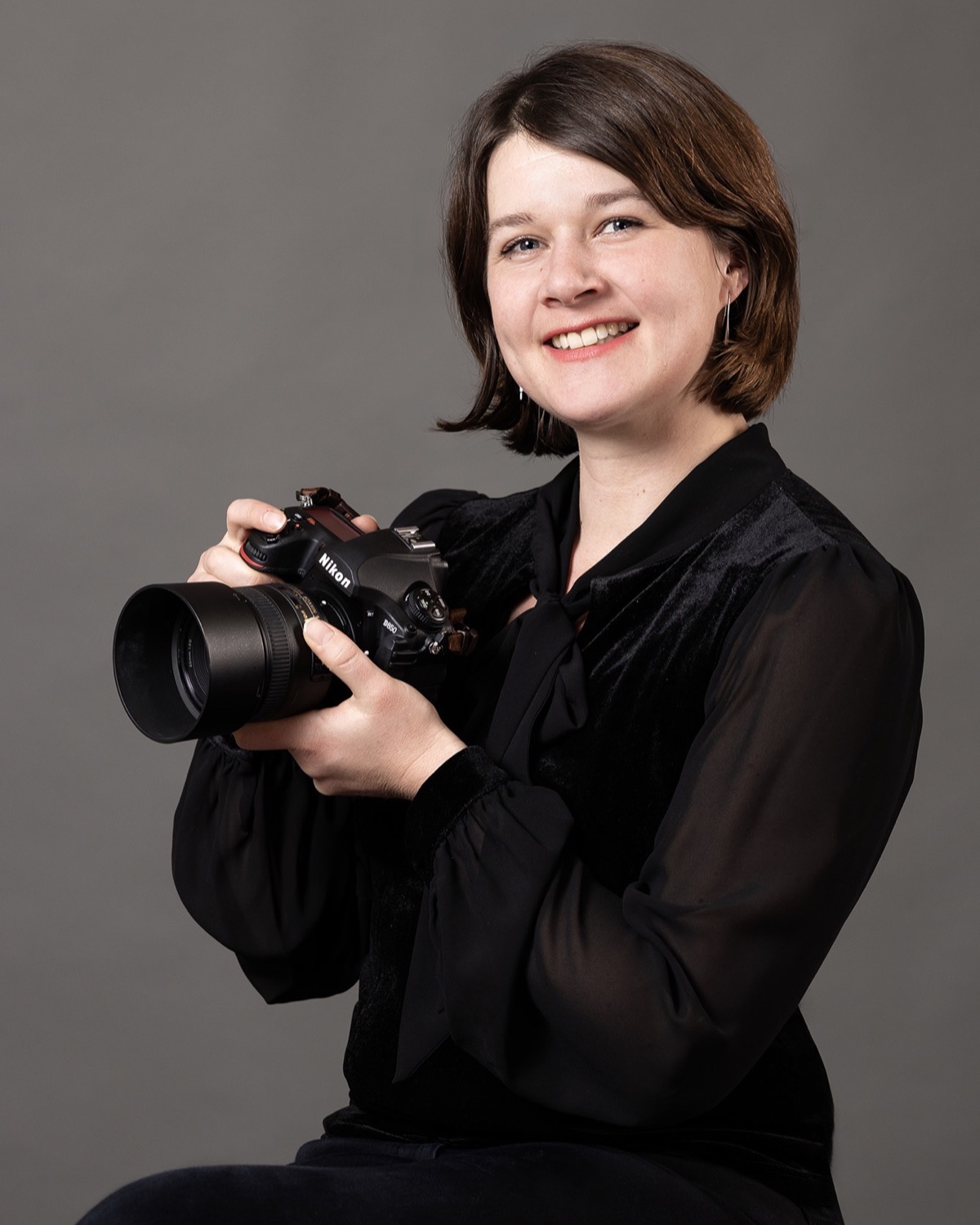 Lucie Poirier, photographe professionnelle à Genève, son appareil photo entre les mains